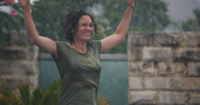 Funny Carefree Young Woman Dancing Alone in the Rain Having Fun Outdoor. Energetic Girl jumping and Moving Enjoy Weather, Freedom and Active Lifestyle. Young Female Person Feeling Free and Happy
