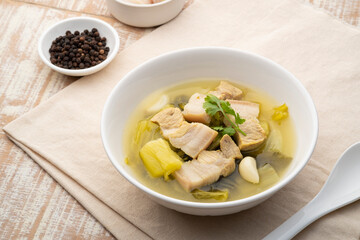 Preserved mustard green with pork belly soup in white bowl