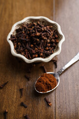 Dried and powdered cloves on a wooden table