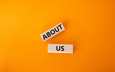 About us symbol. Wooden blocks with words About us. Beautiful orange background. Business and About us concept. Copy space.