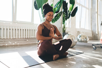 African American woman doing Anjali mudra in sunshine