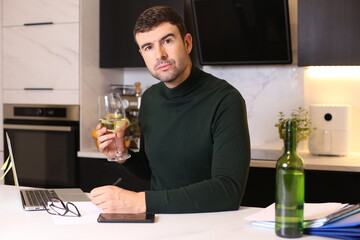 Overworked man drinking white wine
