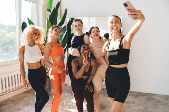 Group of diverse sportswomen taking photo together in gym