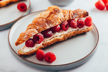 Open Sandwiches for tasty breakfast with croissant, ricotta or cream cheese, fresh raspberries and mint leaves