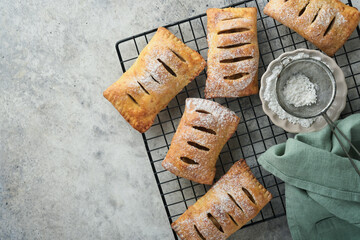 Hand pies. Mini puff pastry or hand pies stuffed with apple and sprinkle sugar powder in wooden plate. Homemade pie snack with crust for breakfast rustic photo.  Copy space. © kasia2003