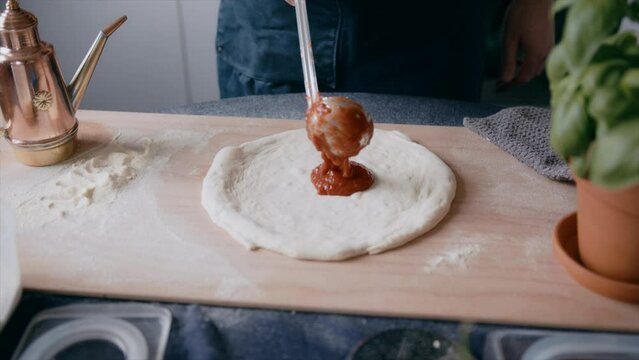 Pizzaiolo Putting San Marzano Tomato On A Sourdough Pizza Base At Home