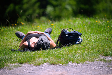 person relaxing on the grass - obrazy, fototapety, plakaty