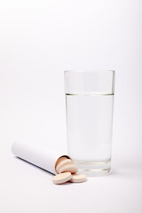 Vitamin C effervescent tablets with orange flavor drops and dissolves in a glass of water isolated on a white background. The concept of health. Medicine concept.