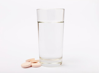 Vitamin C effervescent tablets with orange flavor drops and dissolves in a glass of water isolated on a white background. The concept of health. Medicine concept.
