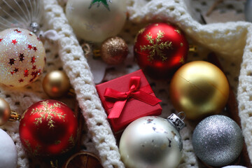 Various colorful Christmas ornaments, small presents and seasonal spices on white knitted blanket. Selective focus.
