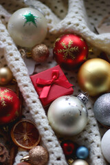 Obraz premium Various colorful Christmas ornaments, small presents and seasonal spices on white knitted blanket. Selective focus.