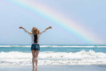 虹の出たビーチで両手を広げる女性 - obrazy, fototapety, plakaty