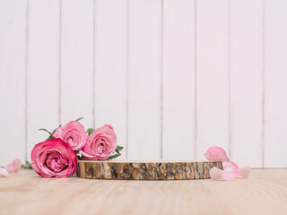 Wooden podium or product stage with pink roses on white wooden background.