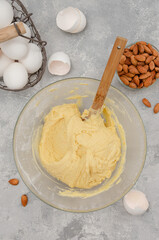 Recipe step by step. The process of making Italian cantucini cookies. Finished dough in a bowl on a gray concrete background. Top view.