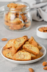 Traditional Italian cantuccini cookies with almonds on a plate on a gray concrete background. Copy space.
