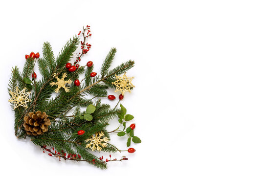 Natural floral christmas corner - rustic decoration of  green spruce, barberry twigs and wild rose fruits with straw stars, flat lay, copy space