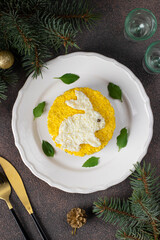 Puff salad Mimosa for the New Year 2023 with canned tuna, potatoes and carrots, decorated bunny from egg, Top view