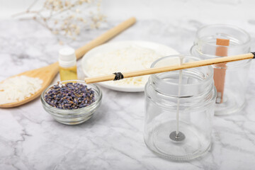 Basic set for homemade natural white eco-friendly soy wax candles in glass, wick, perfume on white marble. Hobby, business. Making candles with your own hands.Vegan product. Copy space.
