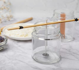 Basic set for homemade natural white eco-friendly soy wax candles in glass, wick, perfume on white marble. Hobby, business. Making candles with your own hands.Vegan product. Copy space.