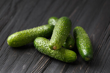 Raw gherkins on a dark wooden background close-up