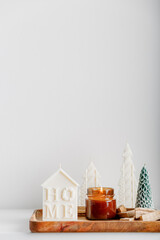 Merry Christmas decoration concept with burning candles and festive decor, christmas trees on light white background. Cozy home. Space for text.