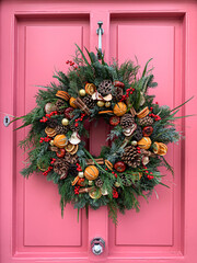 Christmas mood: festive elegant charming christmasy themed winter natural wreath on a pink wooden...