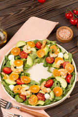 Fototapeta premium Salad with arugula, shrimp, tangerines, avocado, mozzarella and cherry tomatoes, open space