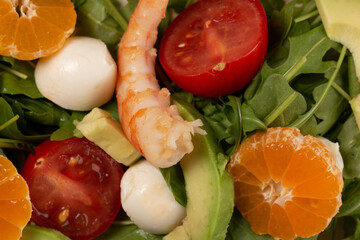 Salad with arugula, shrimp, tangerines, avocado, mozzarella and cherry tomatoes, open space