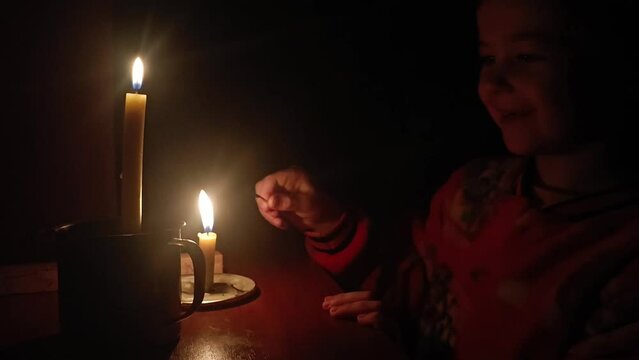 Ukrainian children. War in Ukraine. Children against war. Russian attack on Ukraine's critical infrastructure. The child inraet by candlelight. Blackout in Ukraine. Lack of electricity in Ukraine