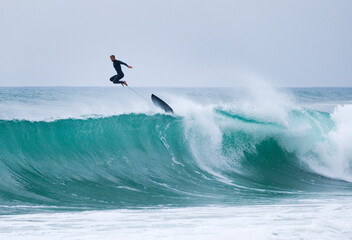 Surfer leaping off a wave, Hossegor, France