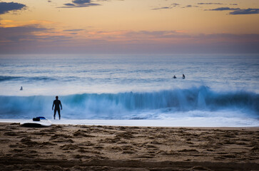 Fototapeta premium Surfers at sunset waves, Hossegor