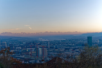 Fototapeta na wymiar Aerial view over City of Zürich with Swiss Alps in the background on a sunny autumn evening. Photo taken December 6th, 2022, Zurich, Switzerland.