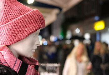 Einkaufen im Winter: Nahaufnahme einer Schaufensterpuppe mit roter Wollmütze und modischen Schal...