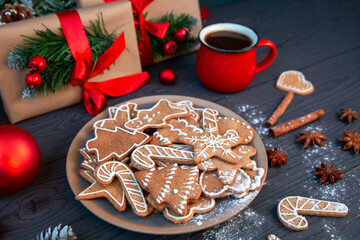 Traditional homemade gingerbread cookies and a cup of coffee among the Christmas decor. Christmas mood, holiday atmosphere.