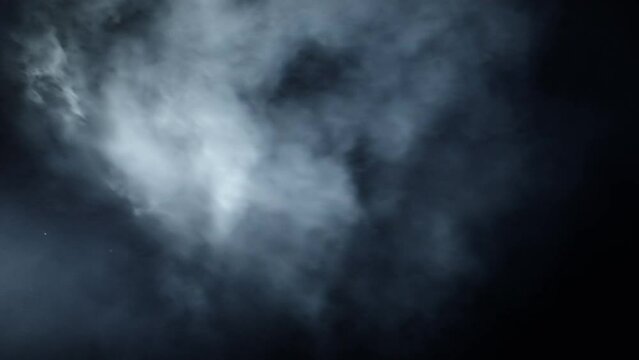 Layered VFX atmospheric clip. The 4K slow-motion atmosphere clip. VFX smoke appears from the side on a black screen, moves slowly, and lingers in the frame, disturbed by a subtle wind.