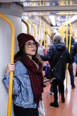 Vertical picture of a hipster woman in winter clothes checking the phone