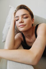 Fototapeta na wymiar Young woman with short haircut hair having fun at home on the couch smile and happiness, vacation at home, natural posing without filters, free copy space