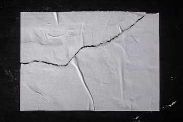 A torn sheet of paper on a black wall.