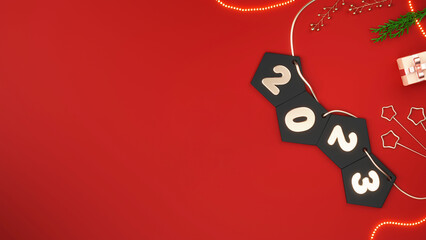 Top View Of 3D Render 2023 Number Pentagon Bunting With Star Sticks, Berry Stem, Fir Leaves, Gift Box And Lighting Garland On Red Background.