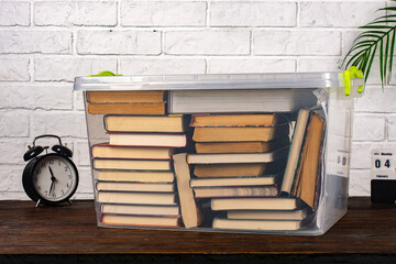 Plastic box with books on the table.