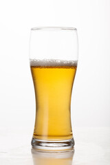 Pint of beer, ale, lager on white background half empty