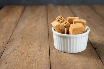 Pacoca is a Brazilian Peanut Sweet. on a white bowl on a wooden deks