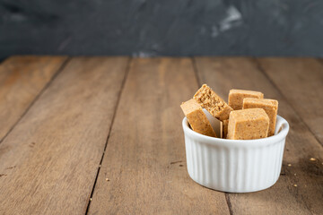 Pacoca is a Brazilian Peanut Sweet. on a white bowl on a wooden deks