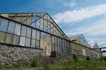 Fototapeta na wymiar Abandoned greenhouses with broken glasses