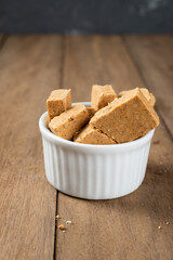 Pacoca is a Brazilian Peanut Sweet. on a white bowl on a wooden deks