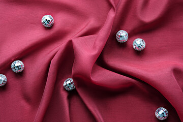 Viva Magenta color of the year 2023. Dark red background. Monochromatic flat lay with disco balls...