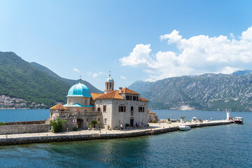 Roman Catholic Church of Our Lady of the Rocks. One of two islets off coast of Perast in Bay of Kotor, Montenegro. Lighthouse on island