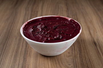 White Bowl of Brazilian Frozen Açai Berry. on a wooden desk