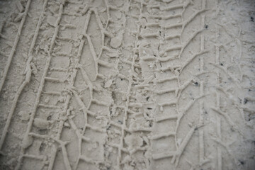 Snow tyre mark. Asphalt covered in snow. Dangerous road conditions. Car imprint on frozen ground. Tire trail on ice.