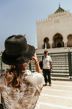 Mujer con sombrero fotografiando a hombre  con gorra en Marruecos 